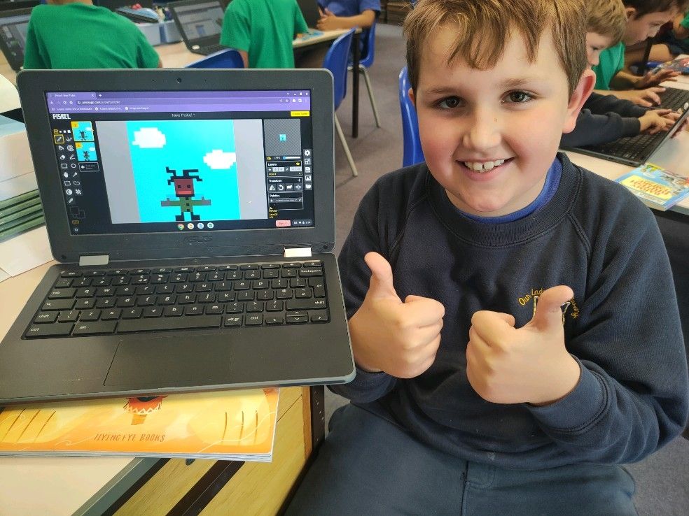 Happy student giving thumbs up with his pixel art creation